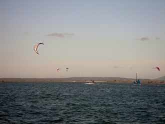 Kite sailors
        off the beach at Isla Coche located off the south shore of
        Margarita Ven