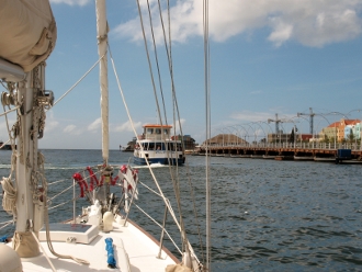 Tundra departs
        Willemsted Harbour with the now operating Pontoon Bridge
        openning ahead
